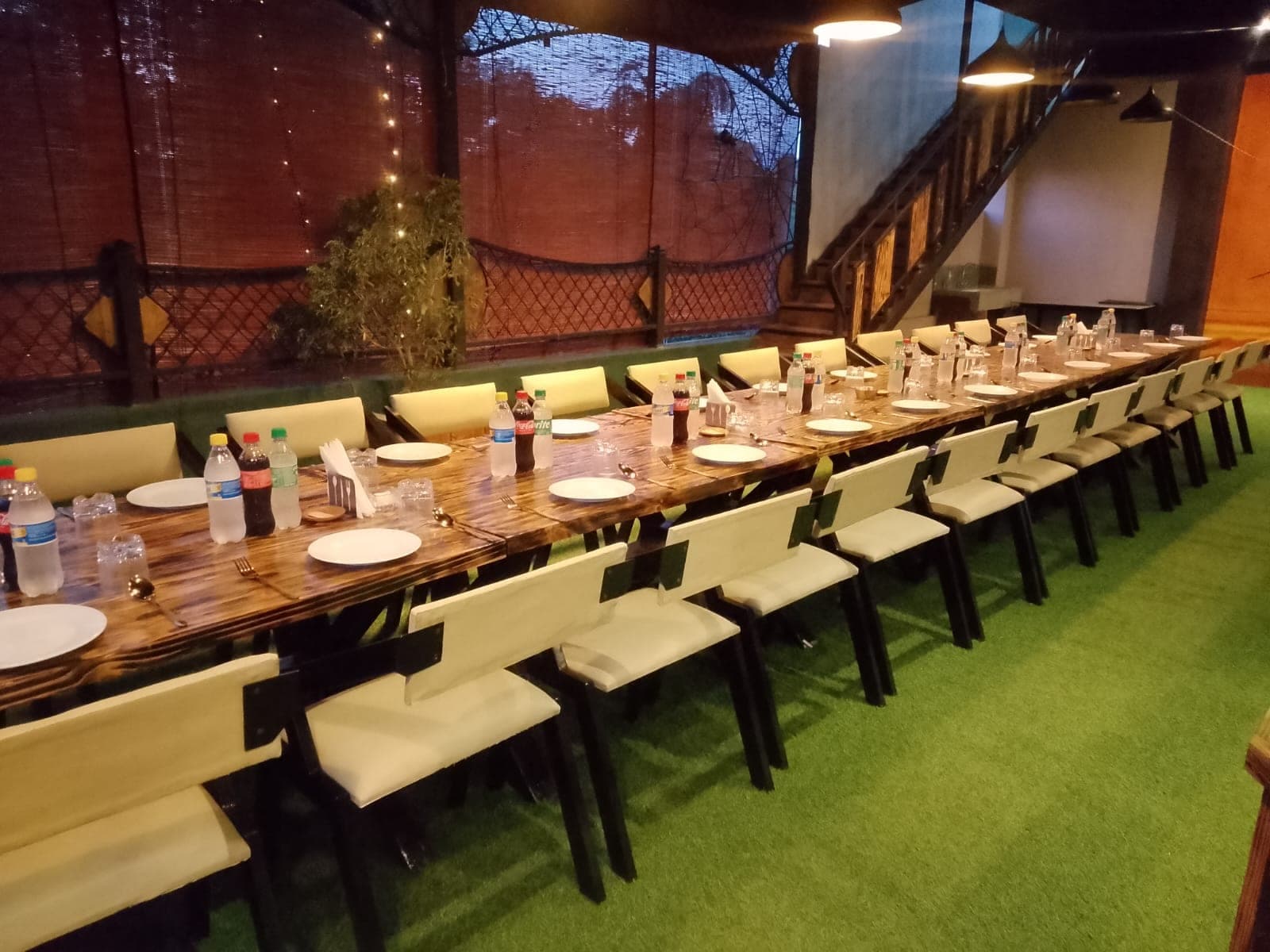 A long banquet table set for a large group on the upstairs terrace